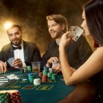 Three people playing poker. The female player shows us her pair of aces.